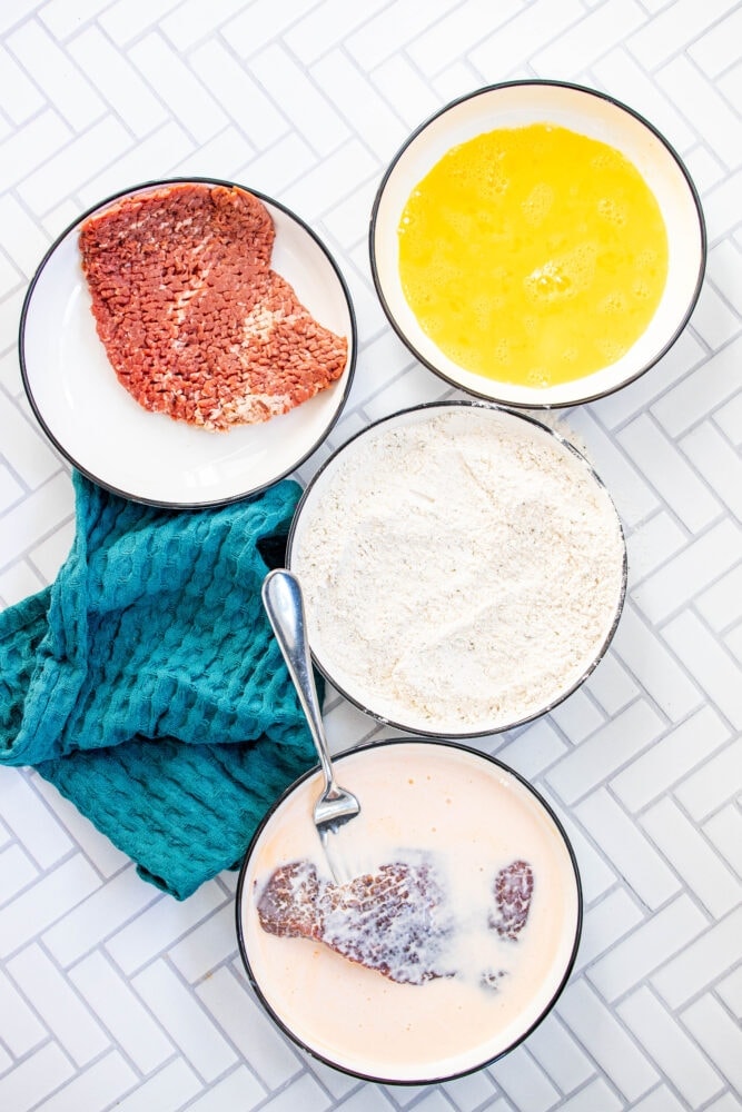 picture of cube steak being dipped in milk 