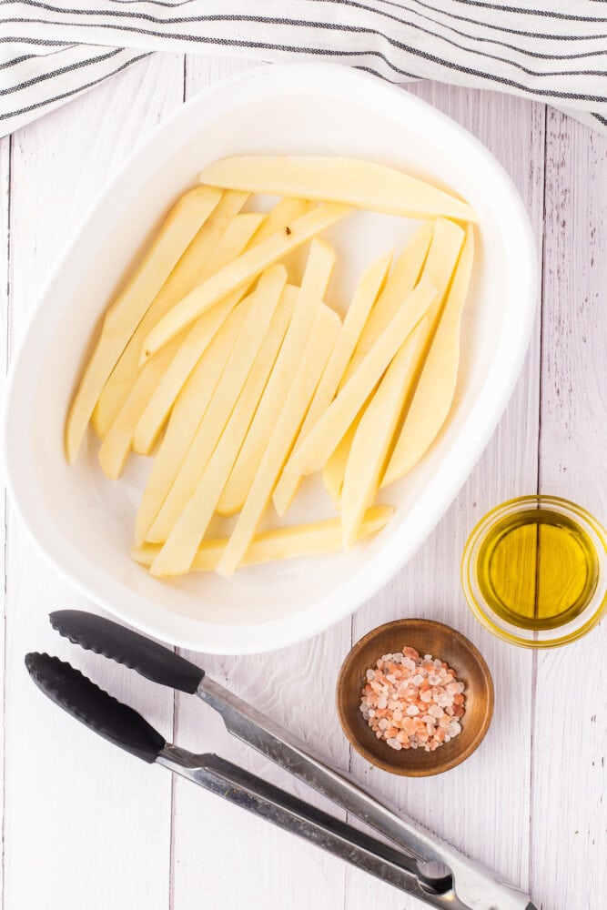 potato tossed in salt and oil in a dish