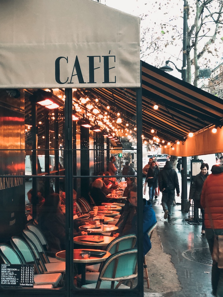 a cafe in paris with Christmas lights