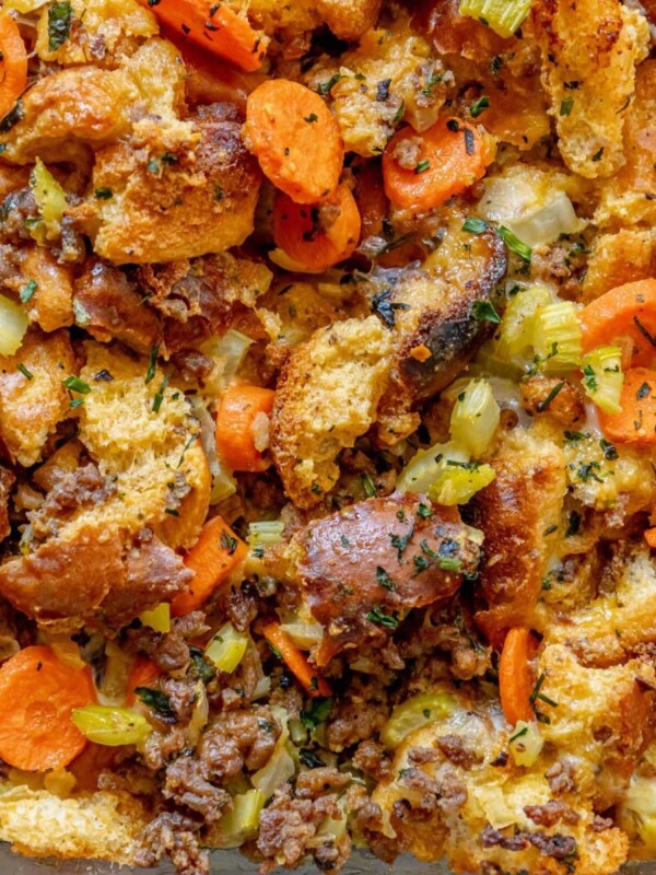 picture of cheeseburger stuffing in a glass tray on a table with carrots and herbs on top