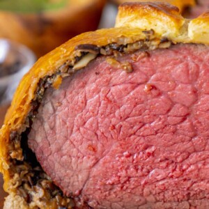 beef wellington wrapped in puff pastry on a cutting board