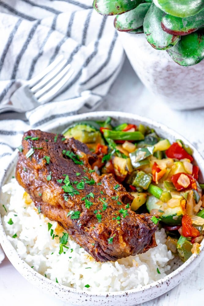 picture of short rib over rice and topped with cilantro and diced onion