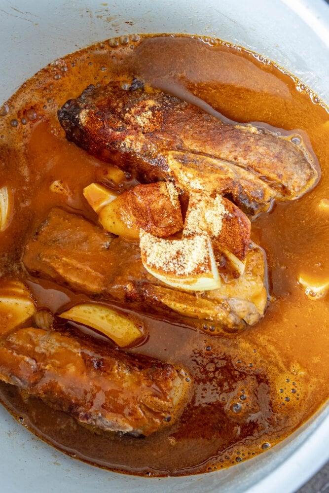 picture of short ribs in an instant pot with spices and beer
