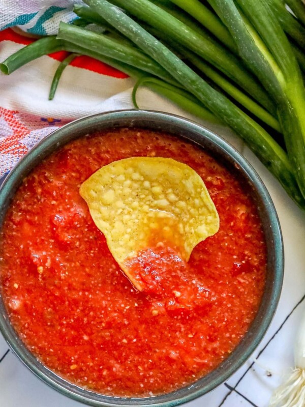 picture of a chip in a bowl of salsa on a table