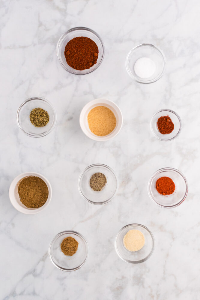 herbs and seasonings in small bowls on a table