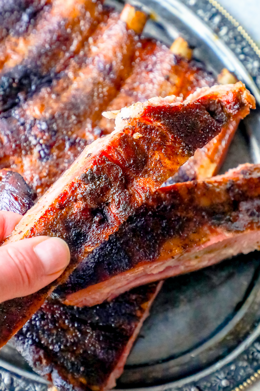 picture of a hand holding a smoked rib